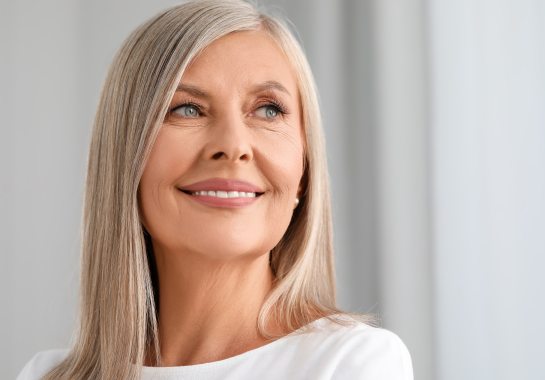 Une femme heureuse après la pose des ses implants dentaires complets